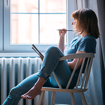 Woman writing by a window 