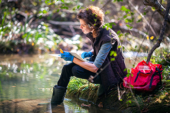 woman observing nature stream