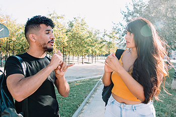 two students signing outdoors